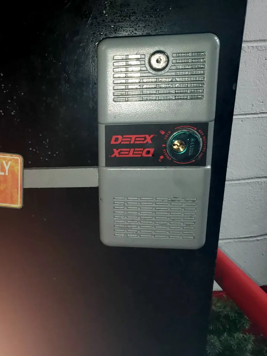 Alarmed exit device with a key switch on a back door, with an emergency exit sign