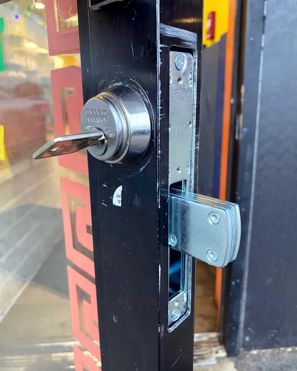High-security deadlock with the key in it on an aluminum storefront door