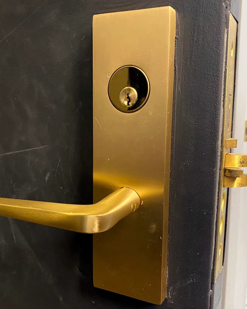 Brass commercial lever lock on a dark restaurant door