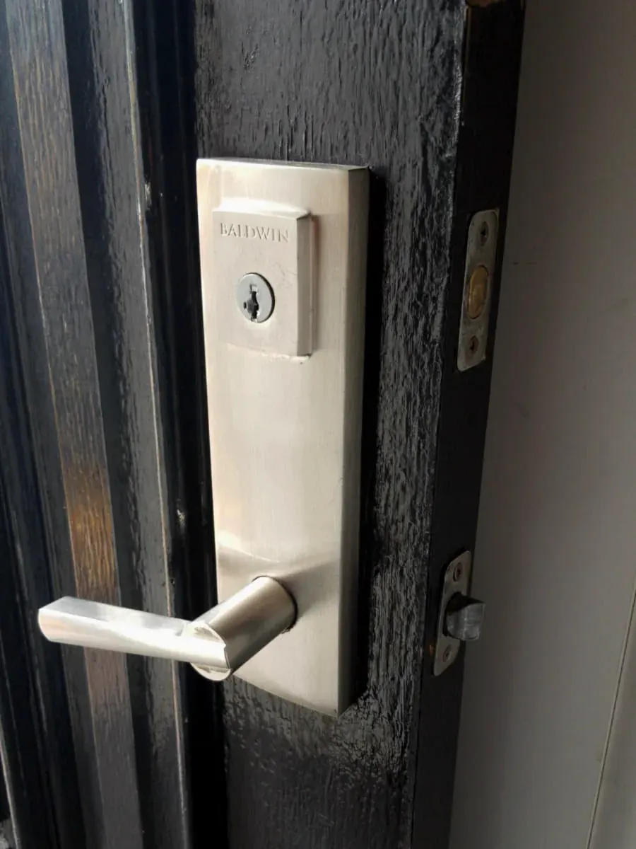 Commercial lever and key cylinder on a dark shop door