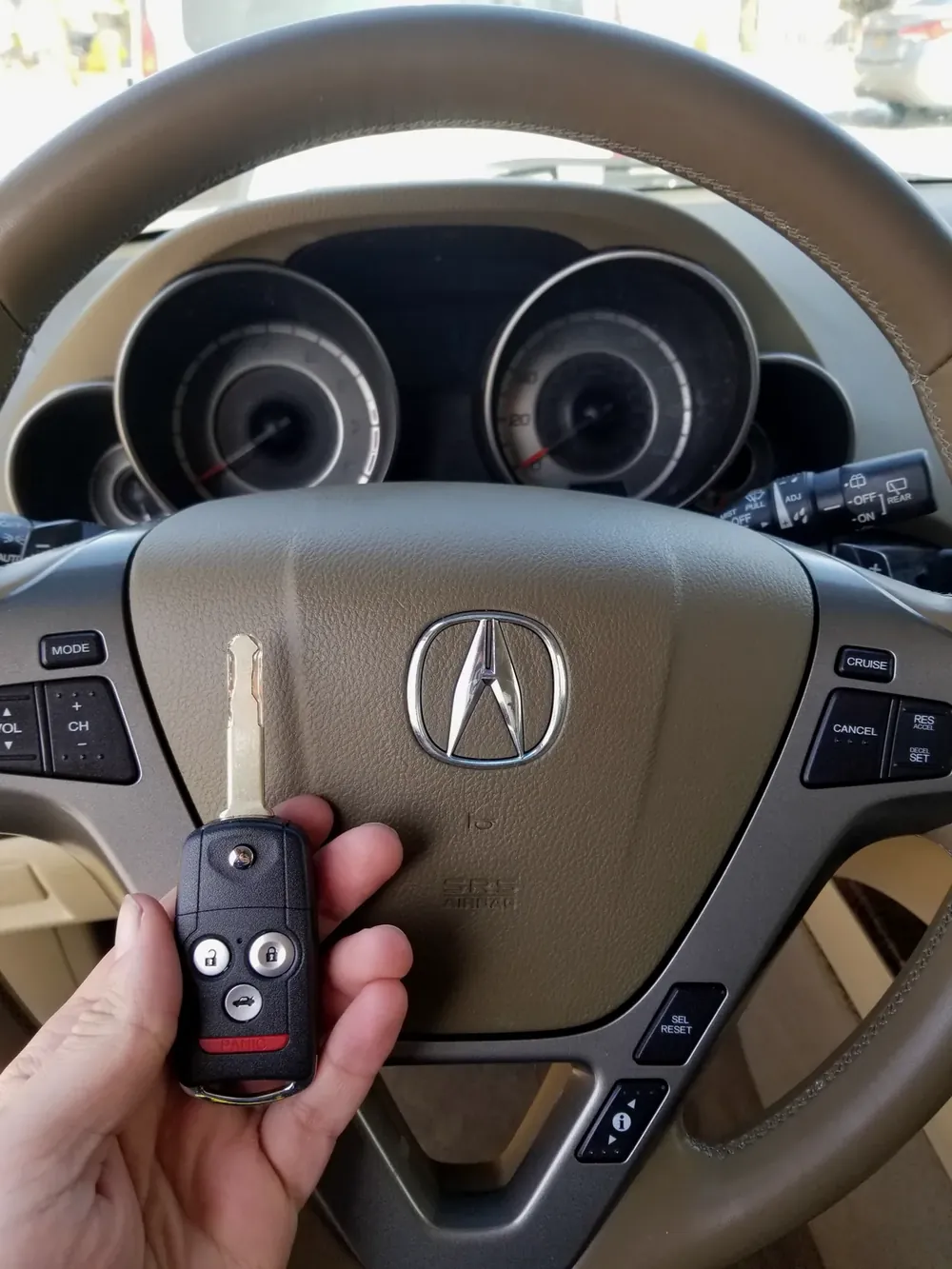 New Acura flip key held at the steering wheel