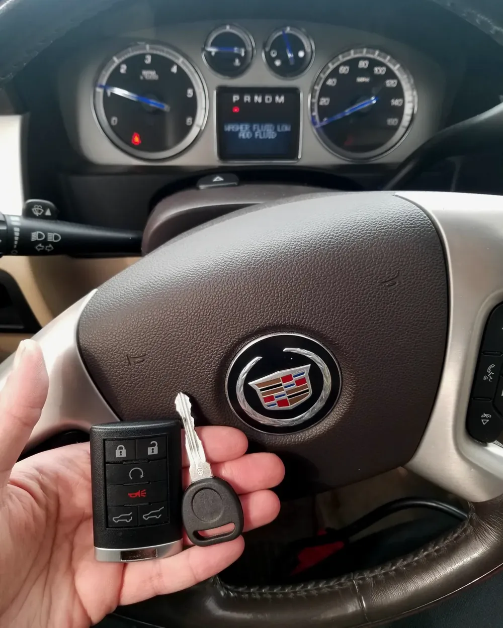 New Cadillac remote and transponder key held at the steering wheel after a job in Elmont, NY