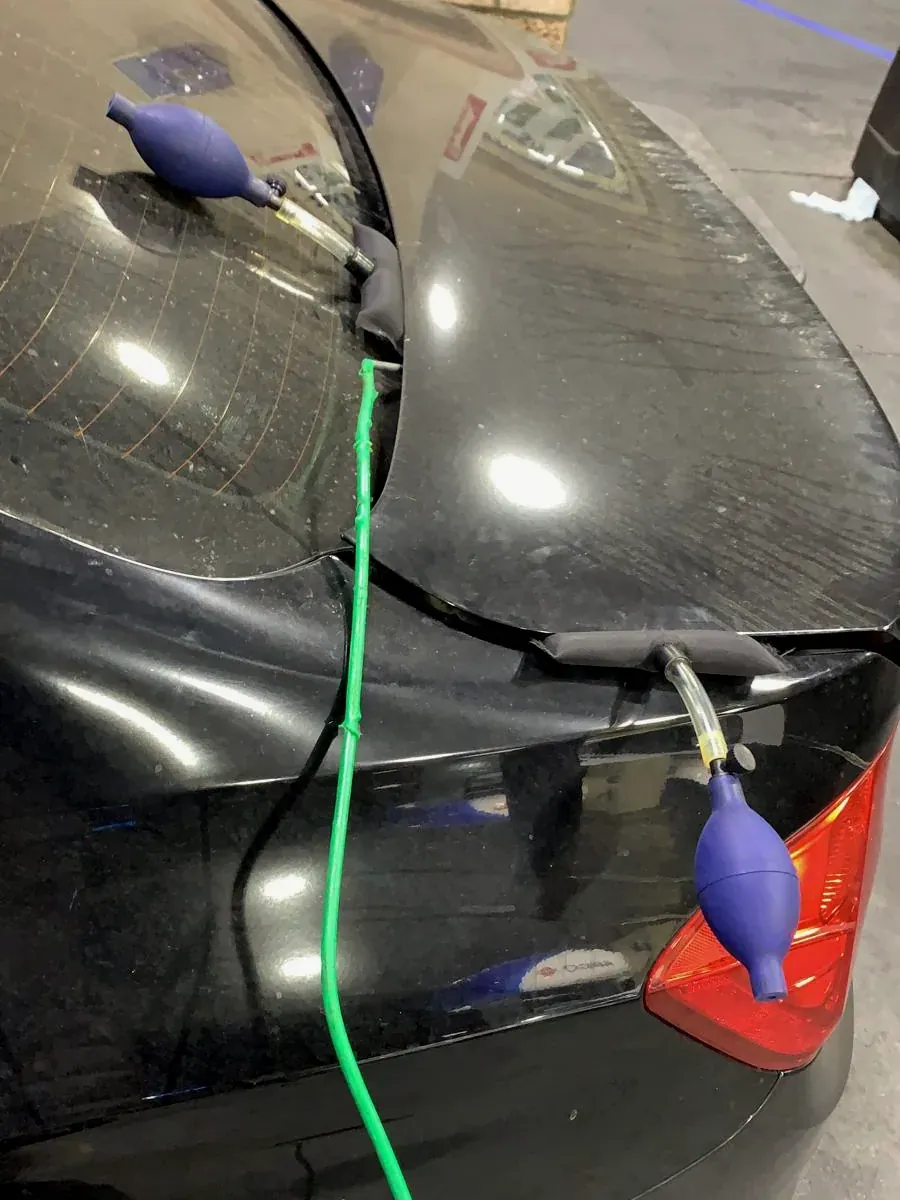Air wedges and a reach tool opening a locked black car without damage
