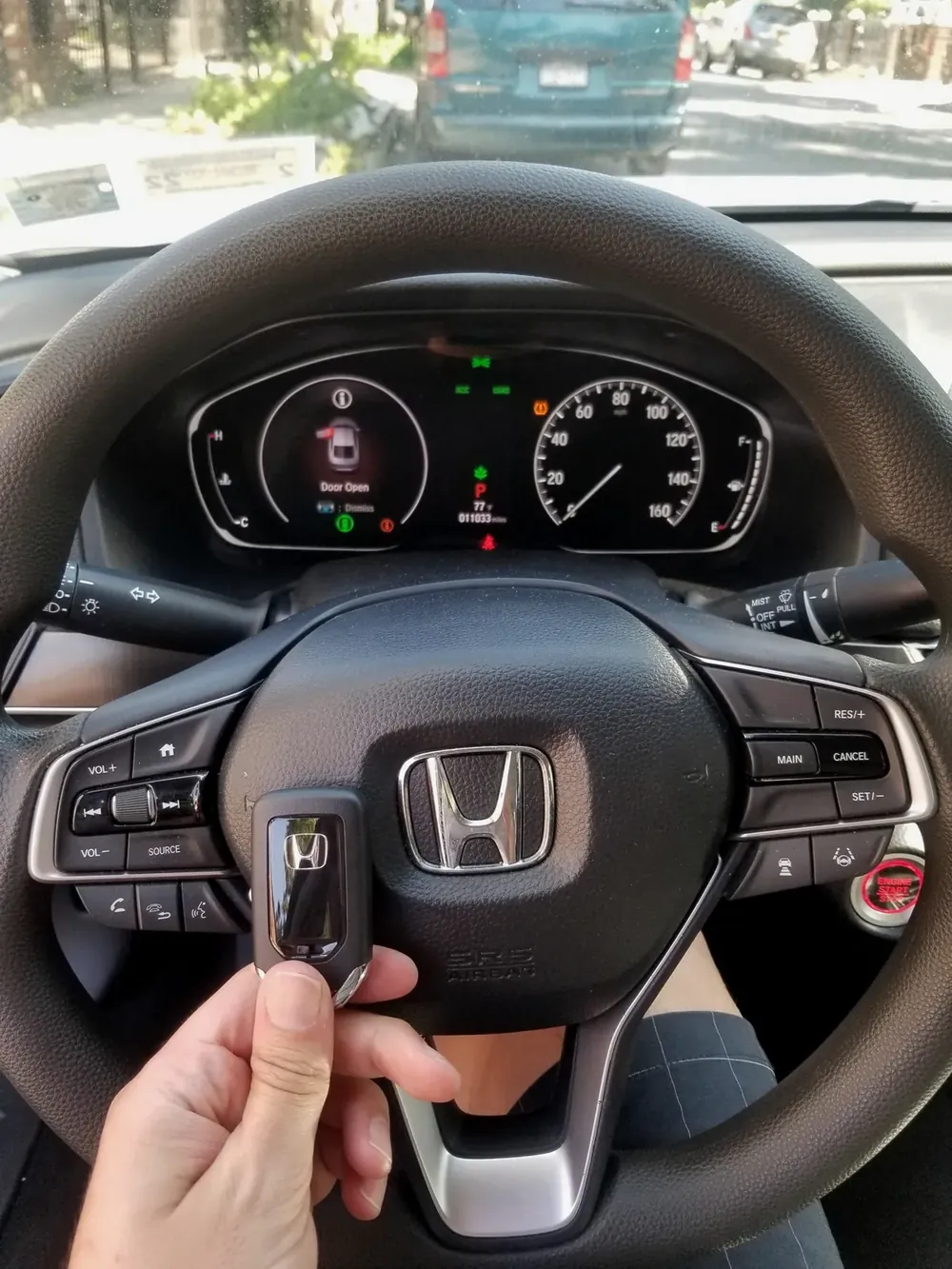 New Honda smart key held at the steering wheel