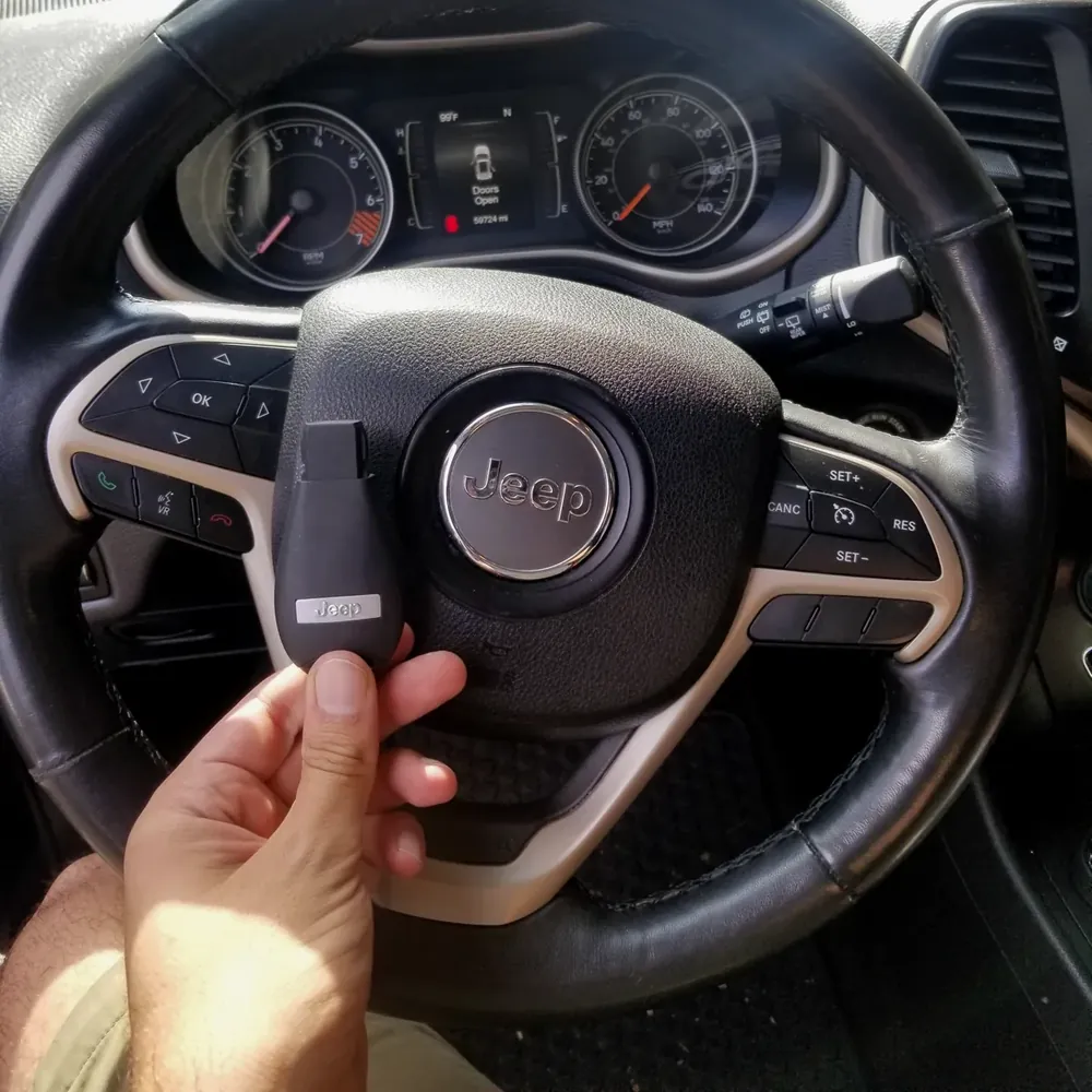 New Jeep smart key held at the steering wheel