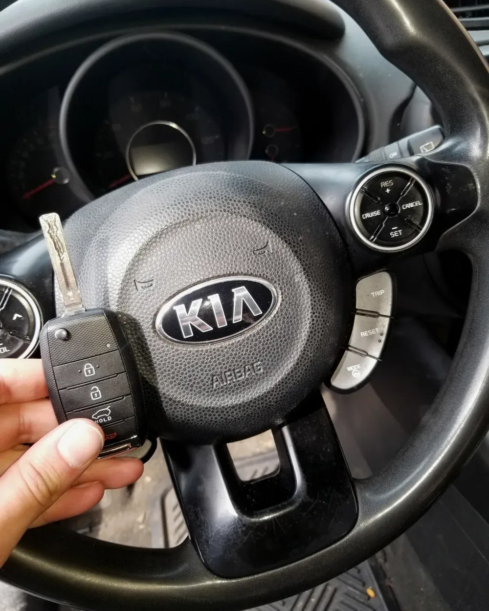 New Kia flip key held at the steering wheel by a locksmith serving Hempstead, NY