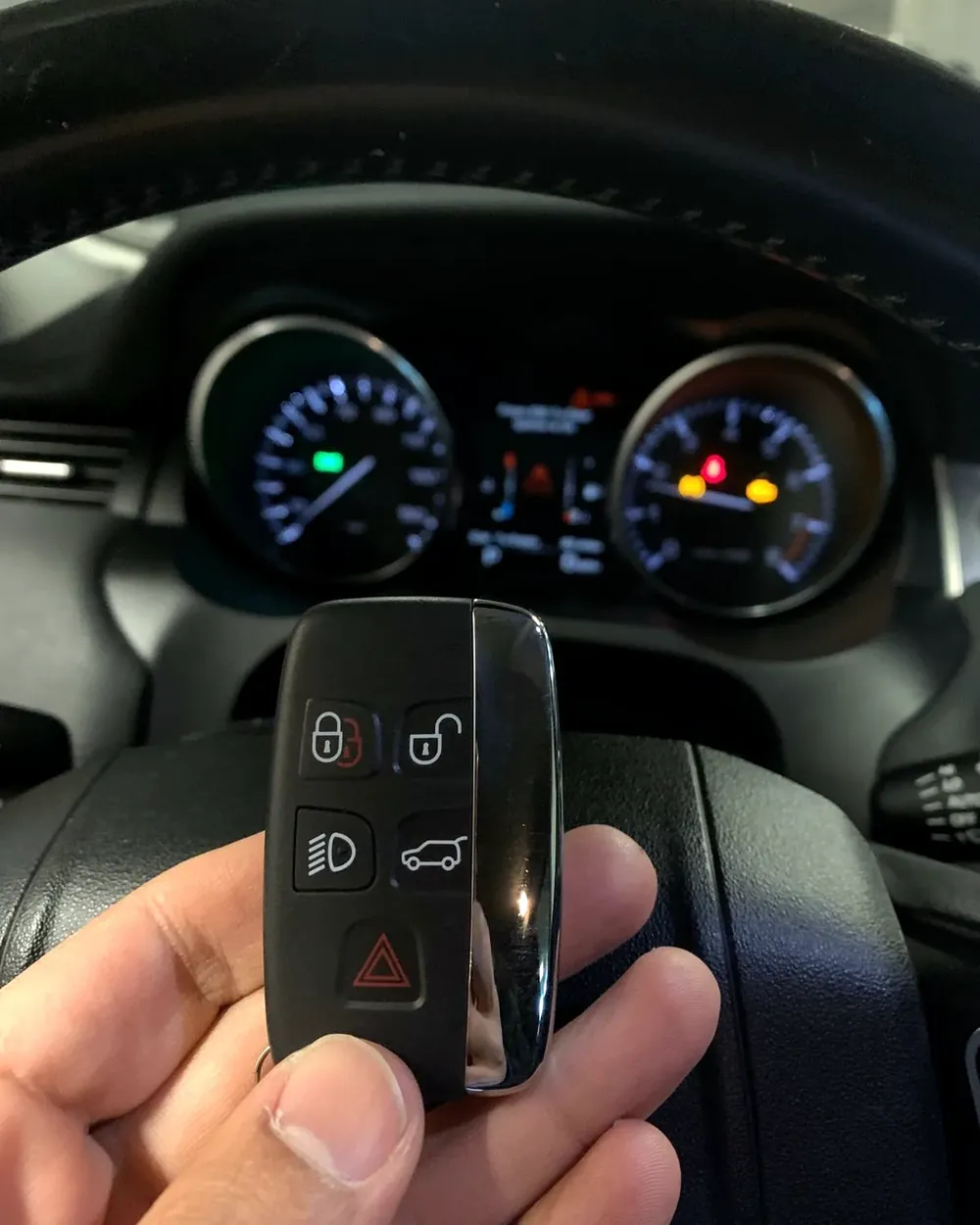 New Land Rover smart key held in front of the lit dashboard by a locksmith serving West Hempstead, NY