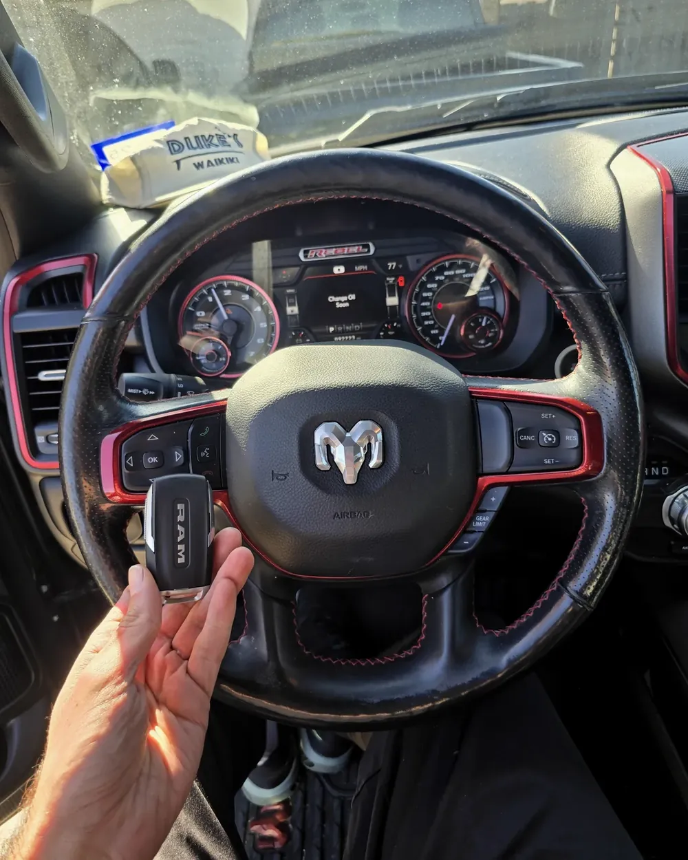 New Ram pickup truck smart key held at the steering wheel by a locksmith serving Freeport, NY
