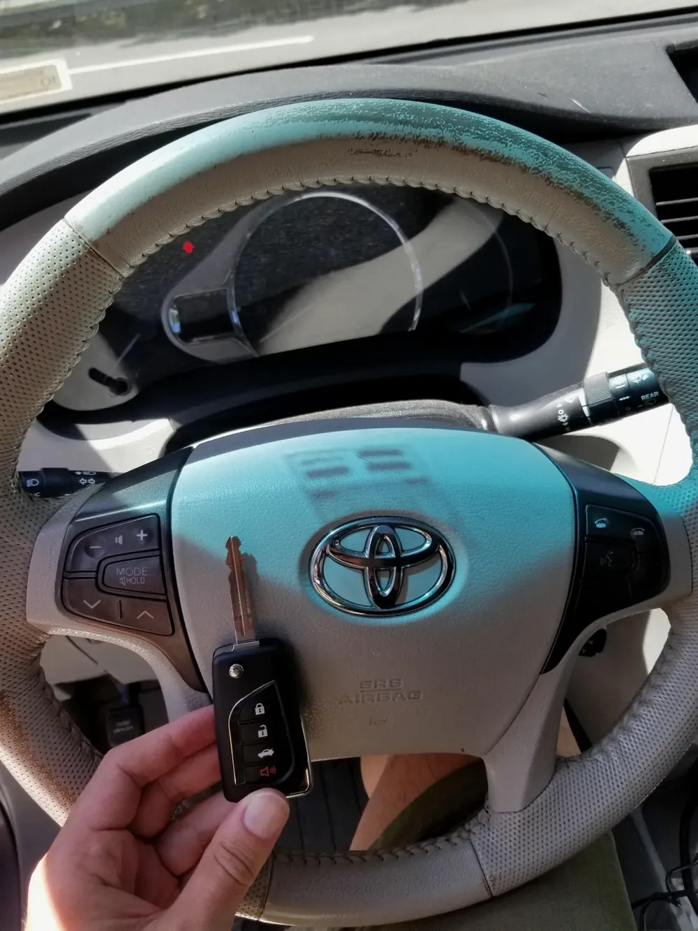 New Toyota flip key held at the steering wheel