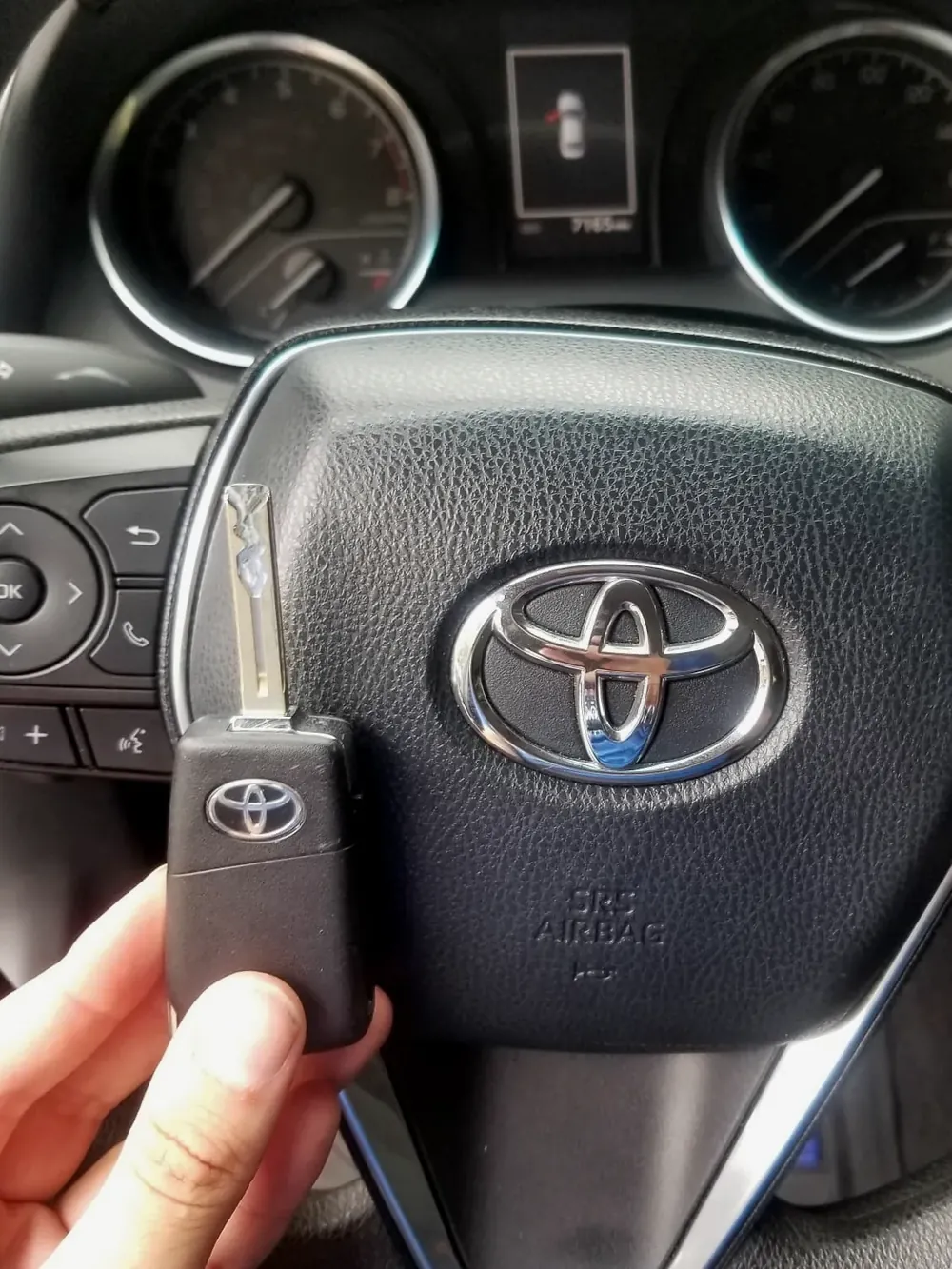 New Toyota flip key held at the steering wheel