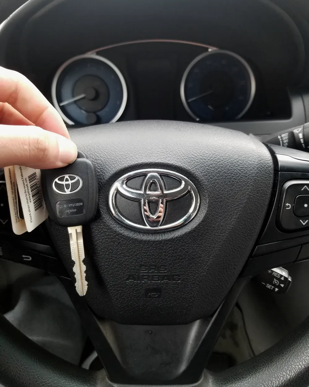 New Toyota key with a tag held at the steering wheel