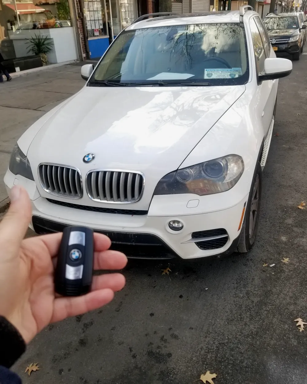 New BMW X5 smart key held in front of the car by a locksmith serving Oceanside, NY