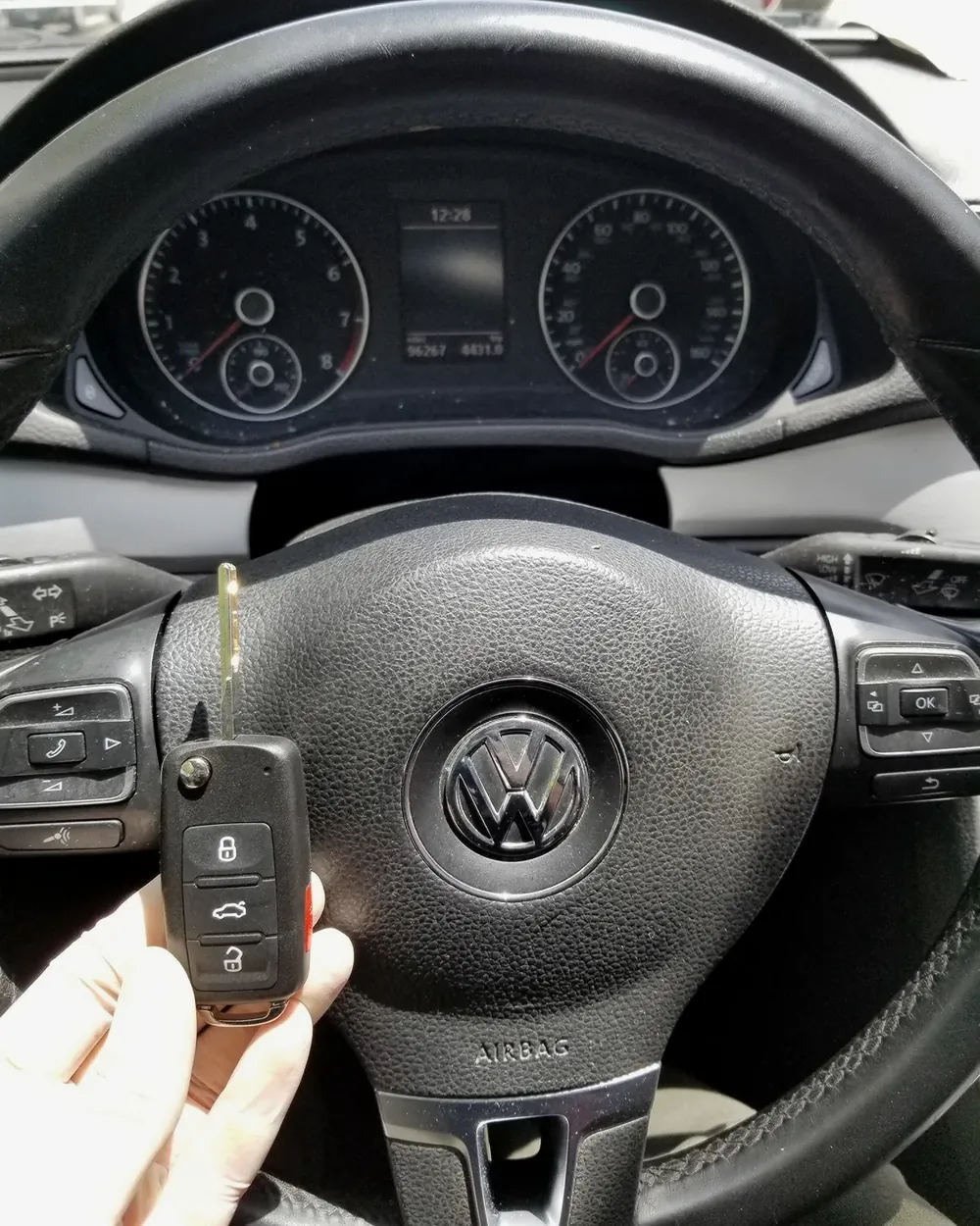 New Volkswagen flip key held at the steering wheel after a job in Garden City, NY