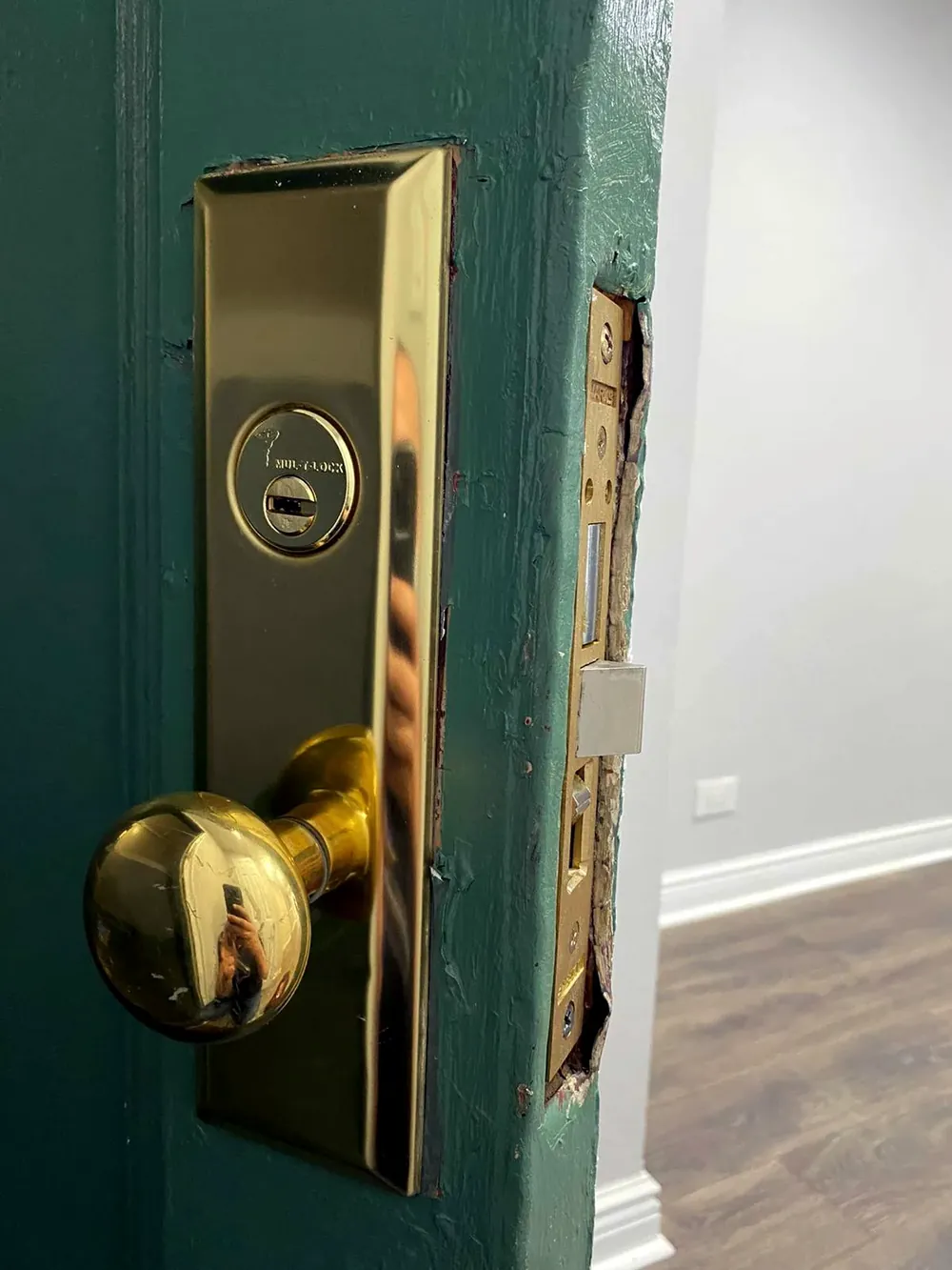 Brass mortise lock and knob on a green apartment door