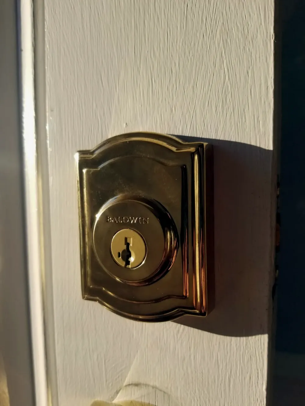 Brass deadbolt on a white front door