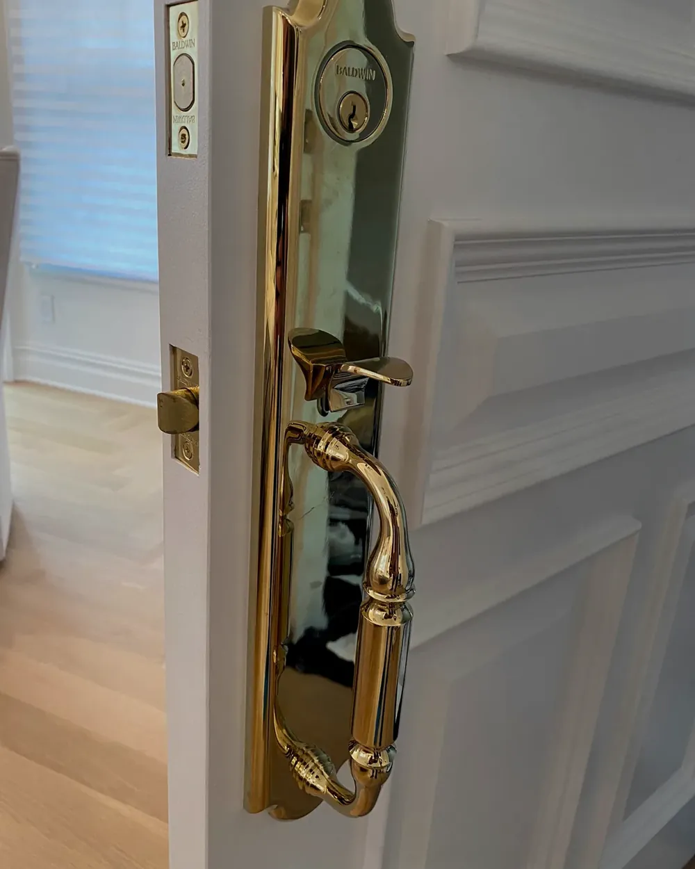 Polished brass handleset with a deadbolt cylinder on a white front door