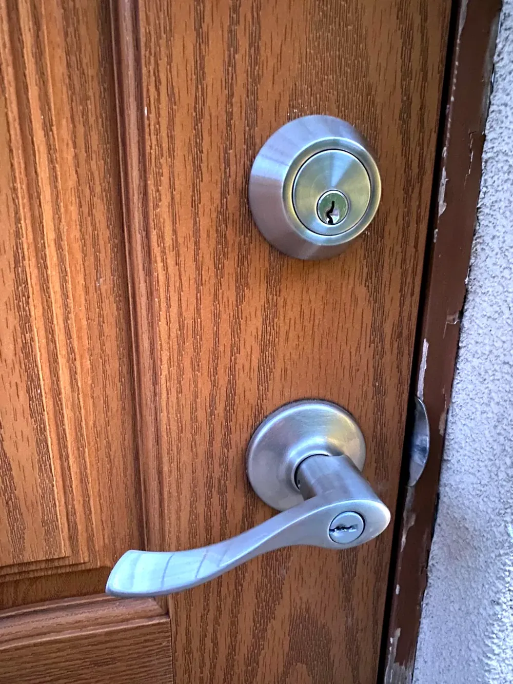 Deadbolt above a keyed lever on a wood front door