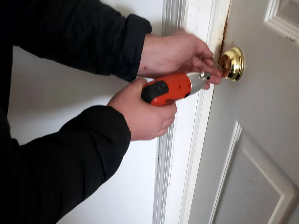 Locksmith using a pick gun to open a locked house door in Nassau County