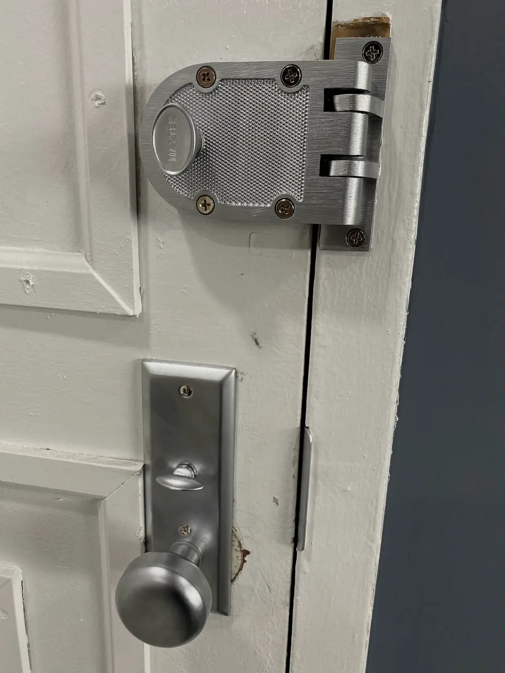 Jimmy-proof deadlock above a knob lock on a white door