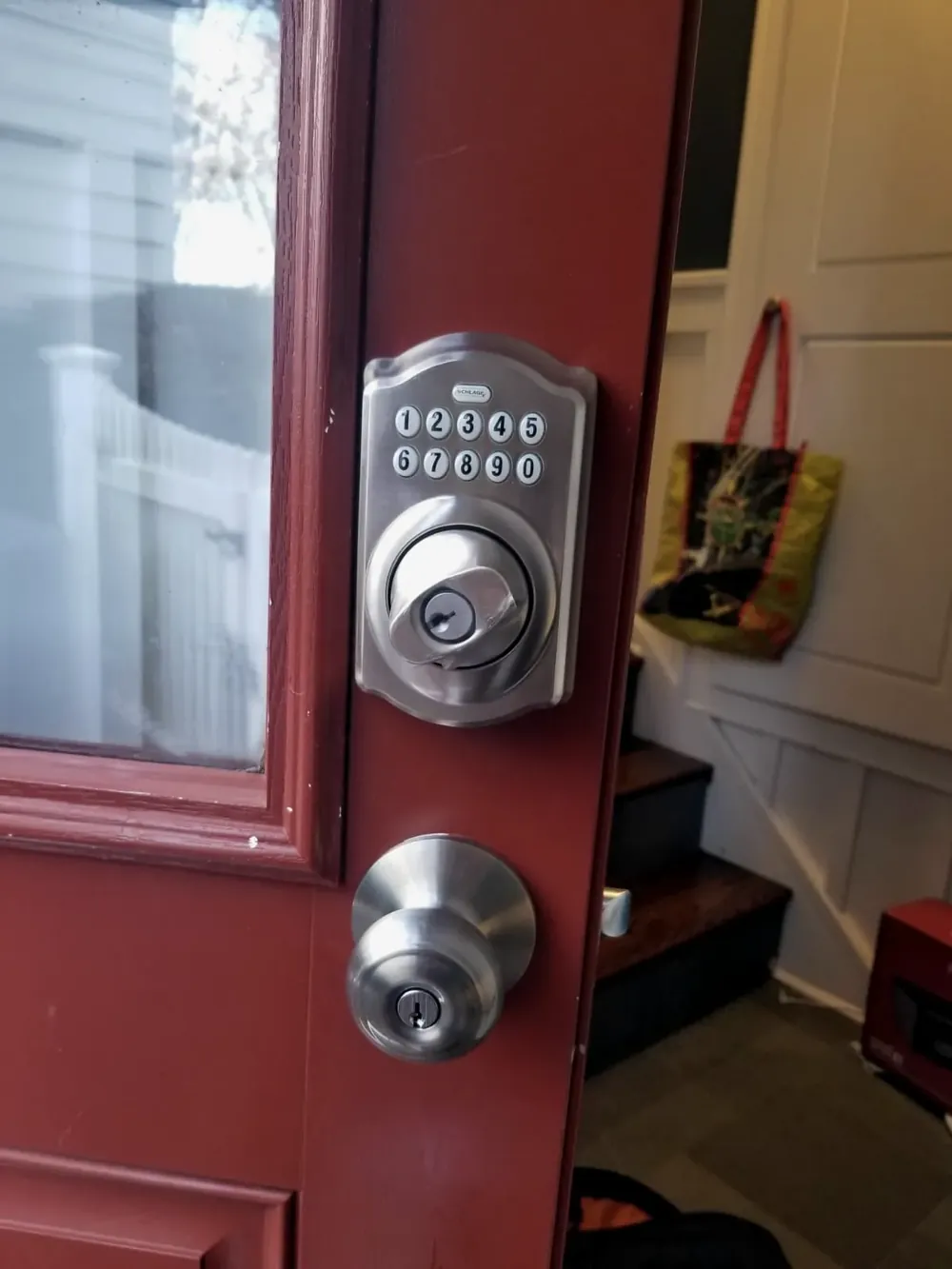 Keypad deadbolt above a knob on a red front door