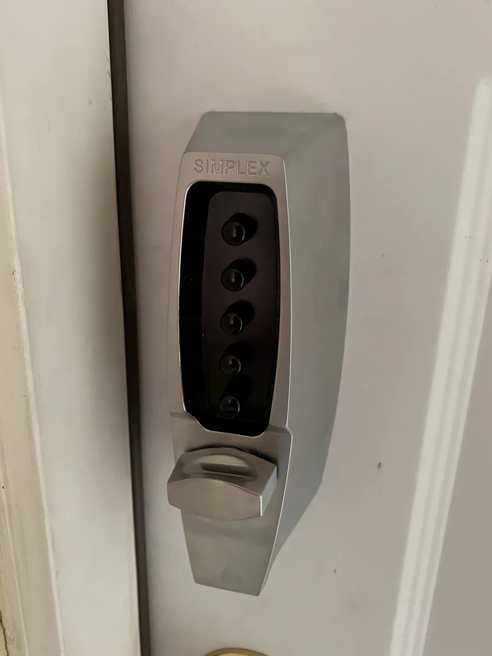 Mechanical push-button code lock on a white door