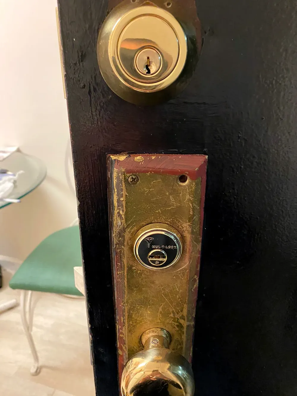 Brass deadbolt and mortise lock cylinder on a black front door