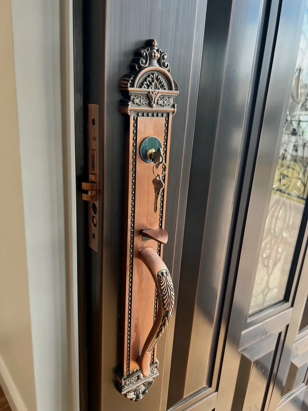 Ornate bronze handleset on a large double front door