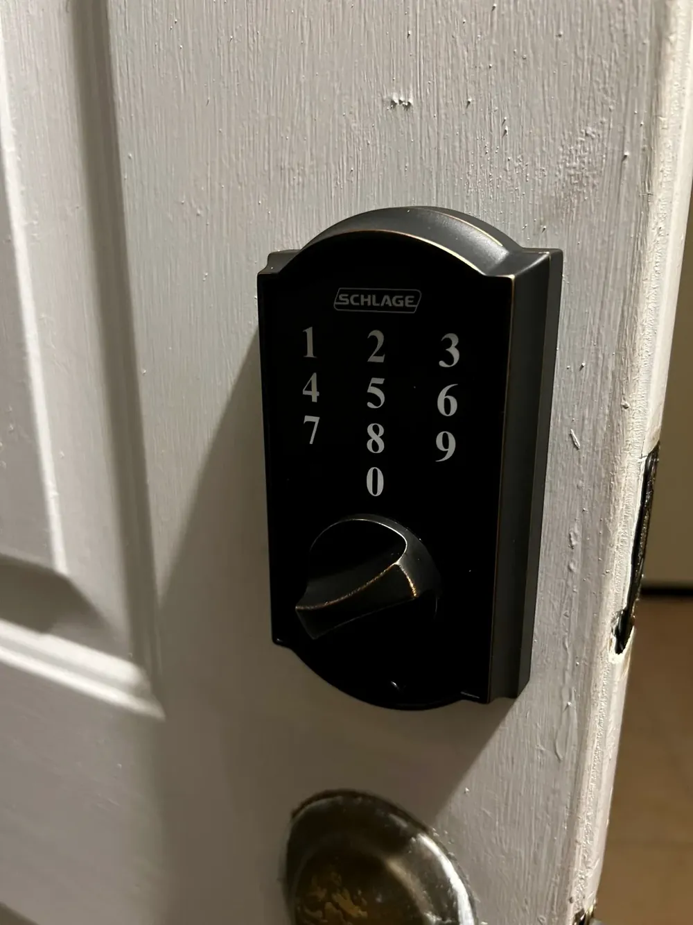 Black touchscreen keypad deadbolt on a white door
